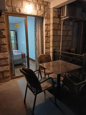 a dining room with a table and chairs and a bedroom at Apartmani OAZA 2 in Ulcinj