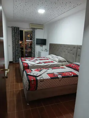 a bedroom with two beds and a television at Apartmani OAZA 2 in Ulcinj