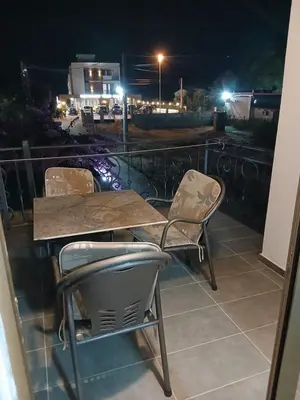 a table and chairs on a balcony at night at Apartmani OAZA 2 in Ulcinj