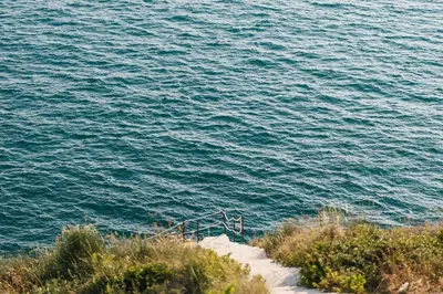 a stairway leading down to the ocean with a body of water at Cottage REE in Ulcinj