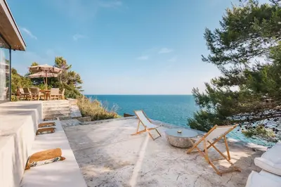 a patio with chairs and a table and the ocean at Cottage REE in Ulcinj