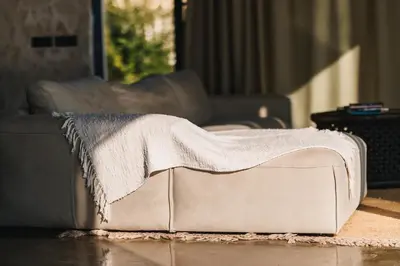 a couch with a blanket on it in a living room at Cottage REE in Ulcinj