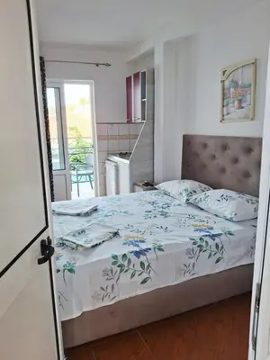 a bedroom with a bed and a kitchen at Apartman Oaza 1 in Ulcinj