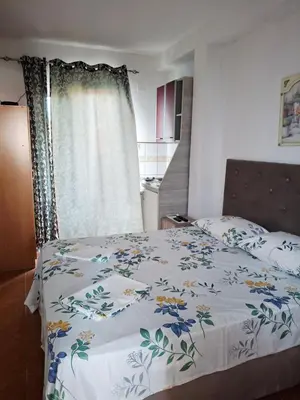 a bedroom with a bed with a floral bedspread at Apartman Oaza 1 in Ulcinj