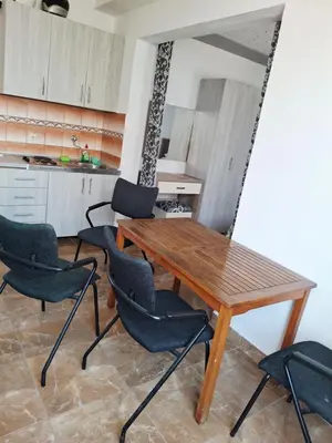a kitchen with a wooden table and four chairs at Apartman OAZA 3 in Ulcinj