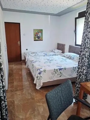 a bedroom with two beds and a table and a chair at Apartman OAZA 3 in Ulcinj