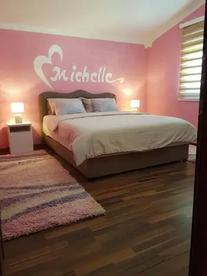 a bedroom with a bed with a pink wall at Apartments Sofia in Bar