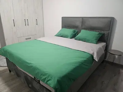 a bedroom with a large bed with green pillows at Apartman Mateo in Cetinje