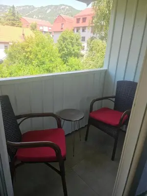 a balcony with two chairs and a table and a window at Apartman Mateo in Cetinje