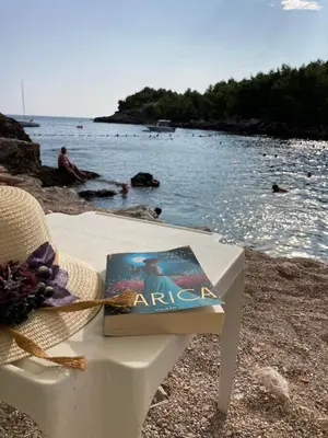 a book sitting on a chair on a beach at Apartmani Sutomore welcome in Sutomore