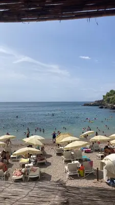 a group of people on a beach with umbrellas at Apartmani Sutomore welcome in Sutomore