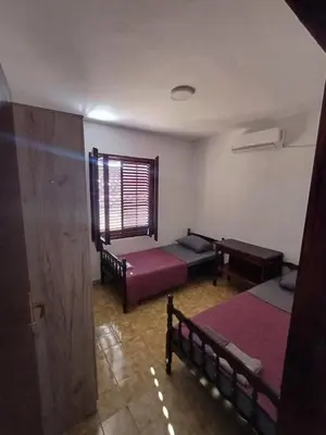 a room with two beds and a window at Apartmani Reef House in Sutomore