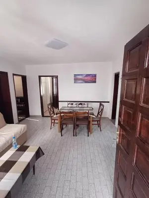 a living room with a wooden table and chairs at Apartmani Reef House in Sutomore