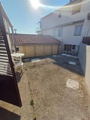 a patio with a table and a fence next to a building at Apartmani Reef House in Sutomore