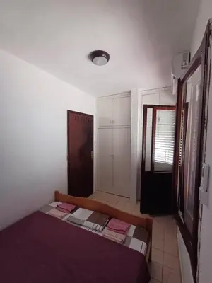 a small bedroom with a bed and a closet at Apartmani Reef House in Sutomore