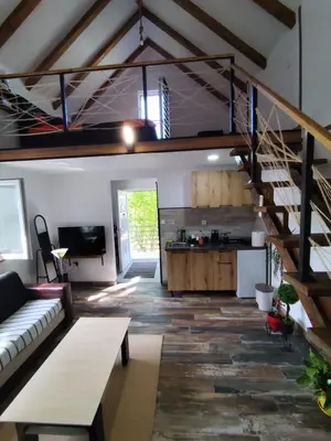 a living room with a couch and a staircase at Cottage in nature of Cetinje in Cetinje