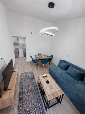 a living room with a blue couch and a table at Rajkovic Stay Bukovik in Bukovik