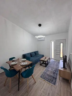 a living room with a blue couch and a table at Rajkovic Stay Bukovik in Bukovik