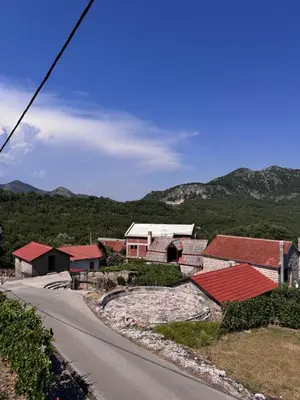 a group of houses on a hill next to a road at Rajkovic Stay Bukovik in Bukovik