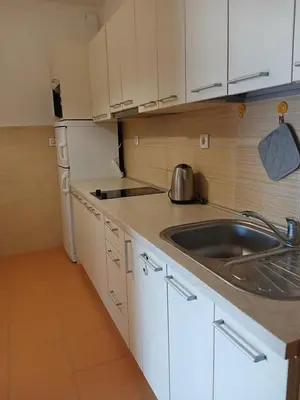 a kitchen with white cabinets and a sink at Apartment EVA in Budva - 55 m2 in Budva