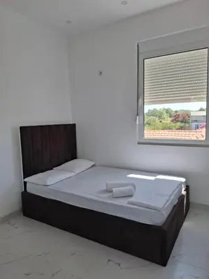 a bed in a white room with a window at Vila stockholm in Donji Štoj