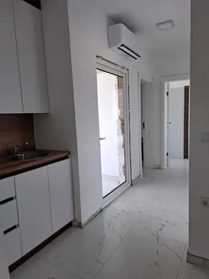 a kitchen with white cabinets and a large window at Vila stockholm in Donji Štoj
