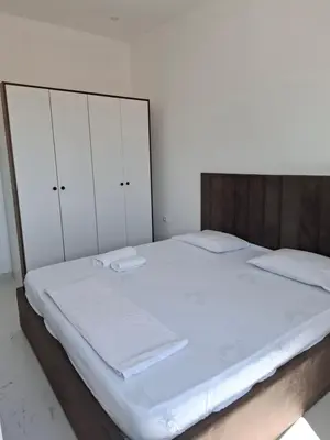 a bed with white sheets and white cabinets in a bedroom at Vila stockholm in Donji Štoj