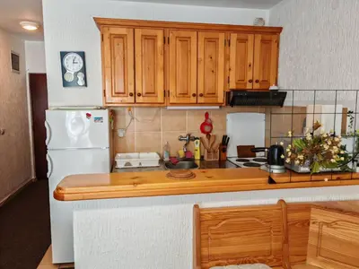 a kitchen with wooden cabinets and a white refrigerator at Apartman Draga Sutomore in Sutomore