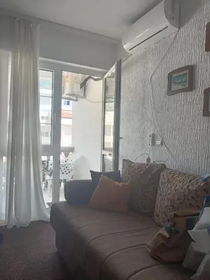 a living room with a couch and a window at Apartman Draga Sutomore in Sutomore