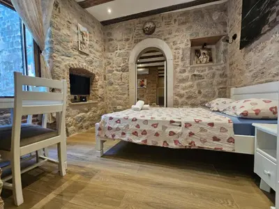 a bedroom with a bed and a stone wall at patrik in Kotor