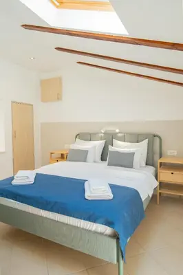 a bedroom with a large bed with blue sheets and pillows at Casa Campana in Kotor