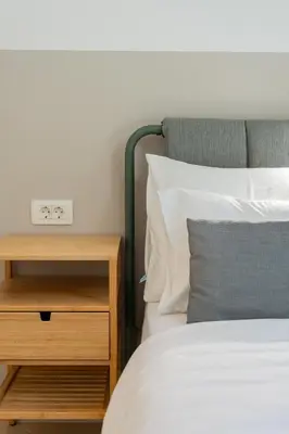 a bed with a night stand next to a bed with a clock at Casa Campana in Kotor