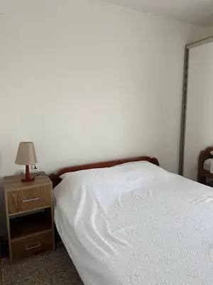 a bedroom with a bed and a night stand with a lamp at DD apartment in Budva