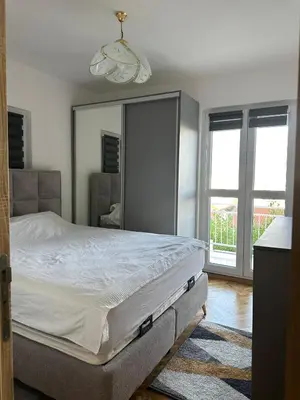 a bedroom with a bed and a large window at DD apartment in Budva