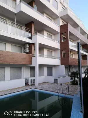 an apartment building with a swimming pool in front of it at Apartman Bucan in Ulcinj