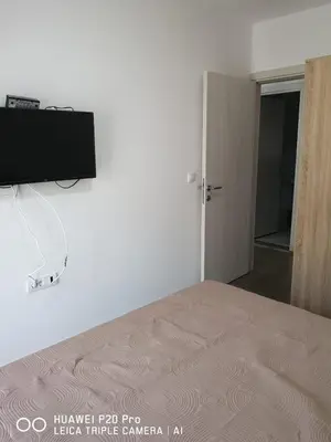 a bedroom with a bed and a flat screen tv on the wall at Apartman Bucan in Ulcinj
