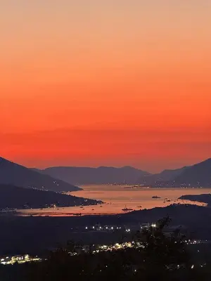 a sunset over a body of water at dusk at A&A apartments in Kravlja