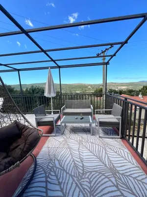 a balcony with a hammock and a table and chairs at A&A apartments in Kravlja