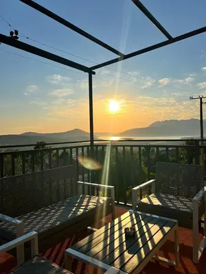 a balcony with a view of the ocean and the sunset at A&A apartments in Kravlja