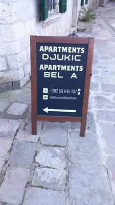 a sign sitting on the side of a street at ground apartaments with balcony in Kotor