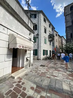 a building with a sign for a restaurant on a street at sar 2 in Kotor