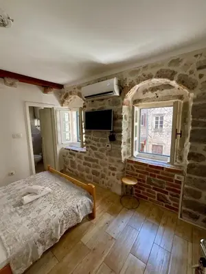 a bedroom with a bed and a brick wall at sar 3 in Kotor