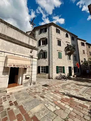 a large stone building with a sign on it at sar 3 in Kotor