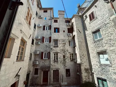 an old stone building with red doors and windows at sar 3 in Kotor