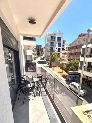 a balcony with a table and chairs and a view of a city at Amd Apartmani in Dobra Voda