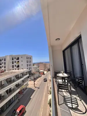 a balcony with chairs and a car on a city street at Amd Apartmani in Dobra Voda