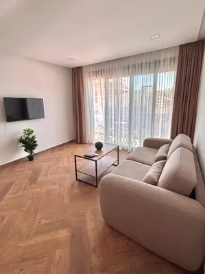 a living room with a couch and a tv at Amd Apartmani in Dobra Voda
