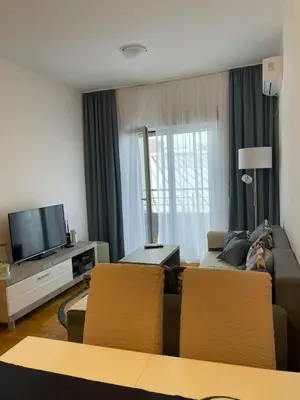 a living room with a couch and a tv at Aurora 3 Apartment in Budva