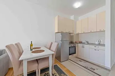 a small kitchen with a white table and chairs at Aurora 3 Apartment in Budva