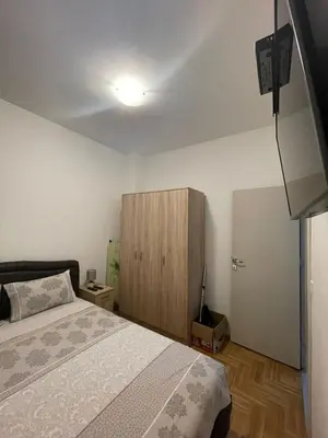 a bedroom with a bed and a wooden cabinet at Aurora 3 Apartment in Budva